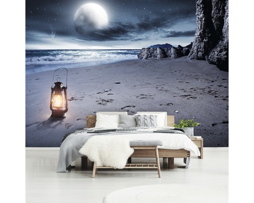 Slaapkamer met fotobehang van een strandscène in maanlicht.