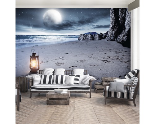 Woonkamer met fotobehang dat een strand ''s nachts met lantaarn laat zien.