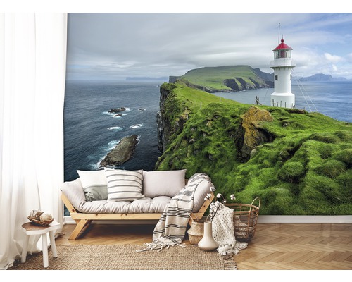 Lichte woonkamer met fotobehang van een vuurtoren op een groene klif