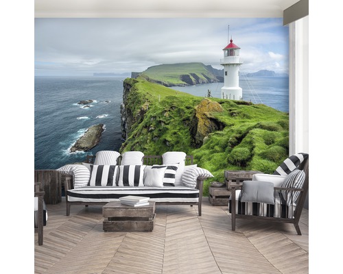 Fotobehang met vuurtoren op een groene klif aan zee