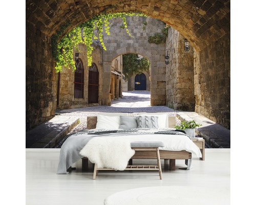 Fotobehang met stenen boogmotief boven een bed