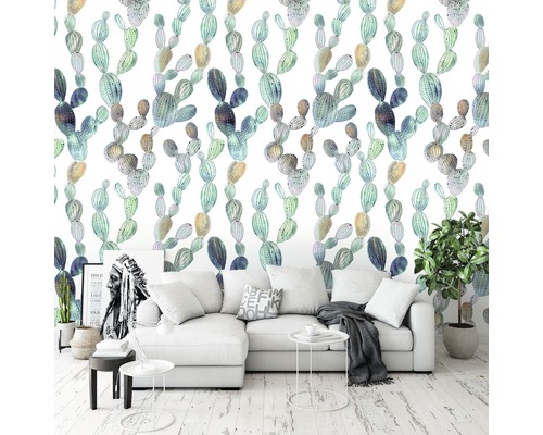 Woonkamer met cactuspatroon behang, witte bank en kamerplanten.