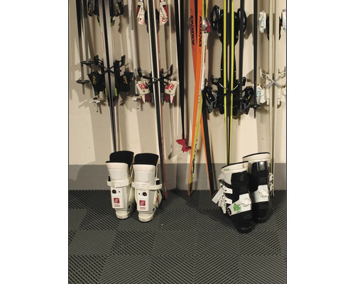Skischoenen en ski''s aan een muur gemonteerd