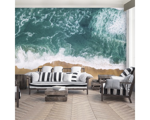 Woonkamer met fotobehang dat een vogelperspectief op een strand en de zee laat zien.