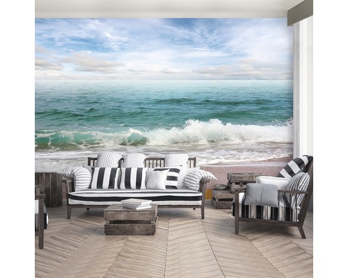 Woonkamer met fotobehang strandmotief, bank en fauteuil