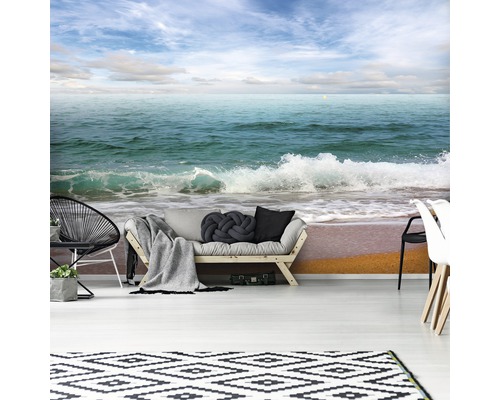 Woonkamer met fotobehang van een zeegezicht, bank, tapijt en stoelen