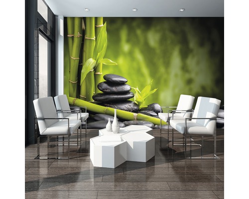 Woonkamer met fotobehang met bamboe en stenen, witte fauteuils en tafel