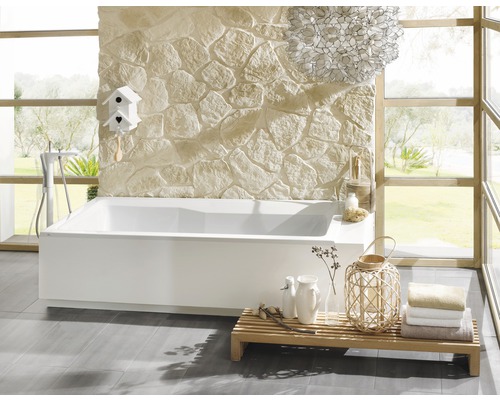 Badkamer met bad, stenen muur en houten plank