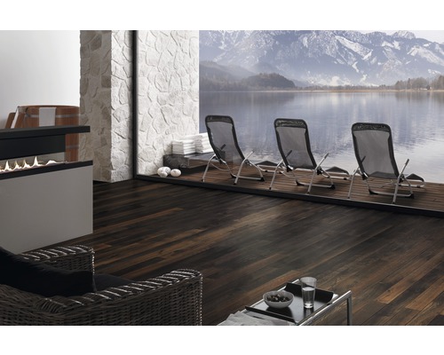 Interieur met donkere houten vloer, ligstoelen en uitzicht op een meer