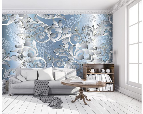 Woonkamer met bank, tafel en boekenkast tegen een muur met een bloemrijk paisley patroon.