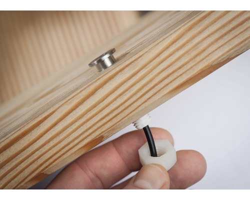 Detailweergave van een houten element met een schroef en een kabelwartel.