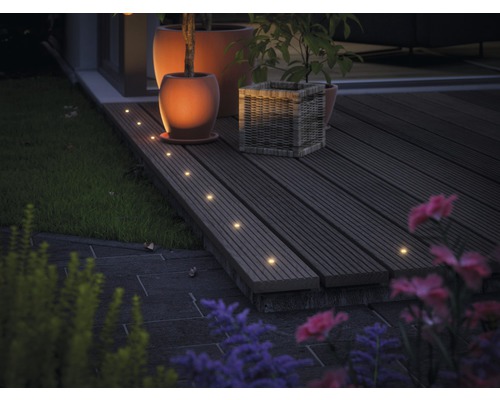 Terras met houten vloer, verlicht met inbouwspots, plus bloempotten en planten