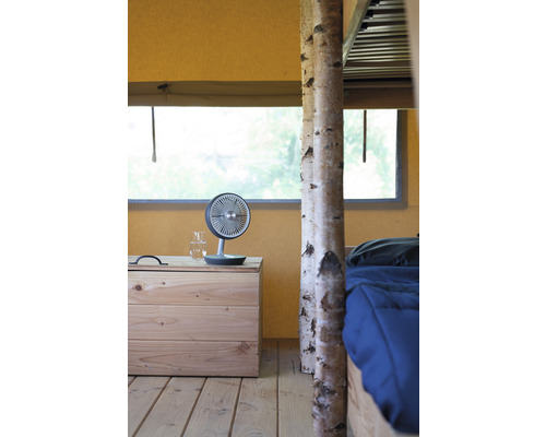 Interieur met tafelventilator op een houten nachtkastje