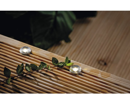 Twee metalen inbouwspots op een houten terras