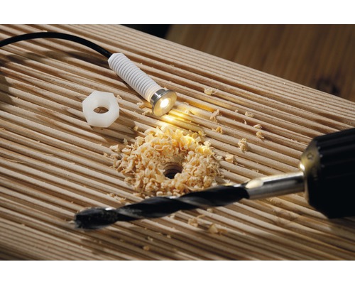 Installatie van een ledlamp in een houten terras met boormachine