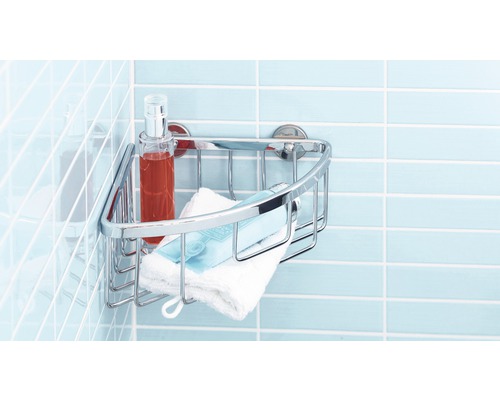 Metalen hoekrek met verzorgingsproducten en handdoek aan een betegelde muur