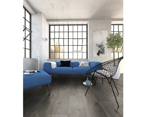 Lichte ruimte met bank, fauteuil en groot raam met roeden