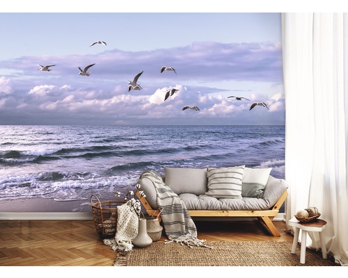 Wandafbeelding met zeegezicht en meeuwen in een heldere, huiselijke kamer.