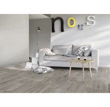 Woonkamer met grijze bank, houten tafel en laminaatvloer