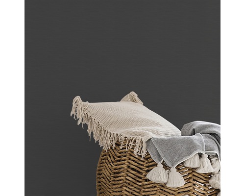 Kussen en deken met kwastjes op een gevlochten mand