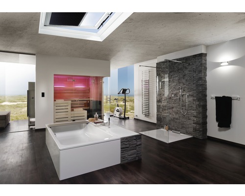 Lichte badkamer met ligbad, douche, sauna en fitnessapparaat voor een groot raam