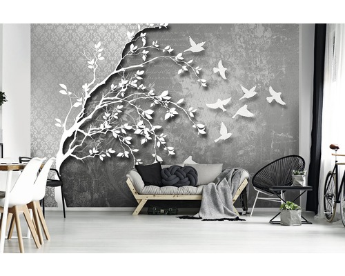 Woonkamer met een fotobehang met een boom en vliegende vogels.