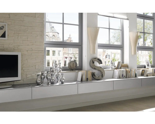 Lichte woonkamer met witte meubels, decoratie en grote ramen.