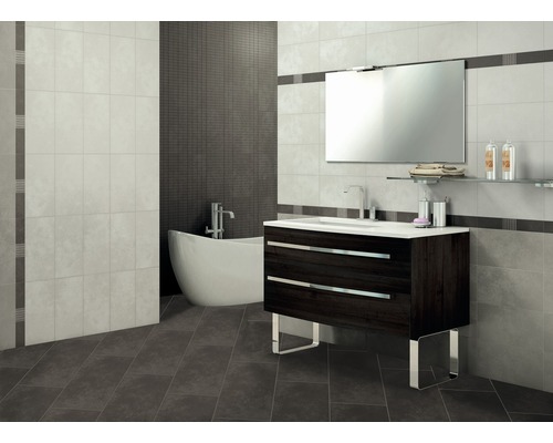 Badkamer met bad, wastafel, spiegel en tegels