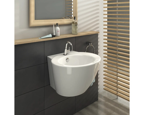 Moderne badkamer met wastafel, spiegel en houten jaloezieën voor een lichte sfeer.