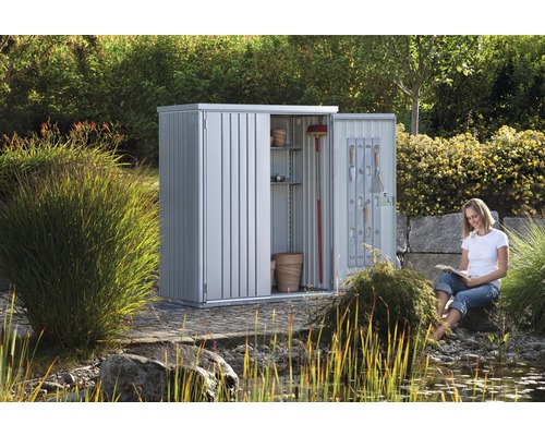 Metalen tuinkast met open deuren en vrouw in de tuin