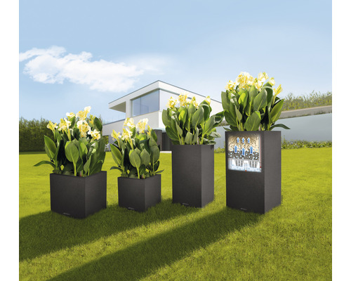Vierkante kunststof plantenbakken met planten in de tuin