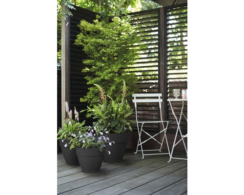 Terrasscène met plantenbakken, privacyscherm en tuinmeubilair