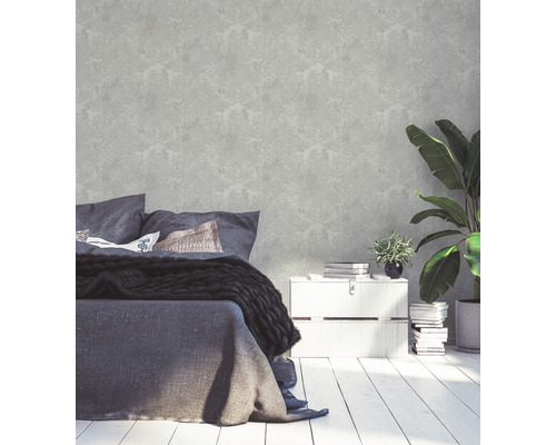 Slaapkamer met patroonbehang, bed, nachtkastje en kamerplanten