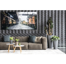 Woonkamer met bank, salontafels, potplanten en een ingelijste foto van treinwagons