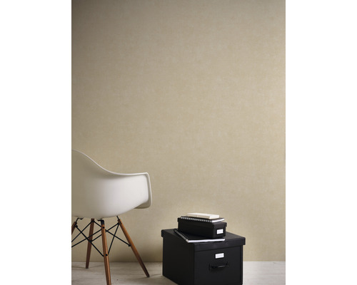 Woonkamer met beige vliesbehang, stoel en zwarte opbergdozen