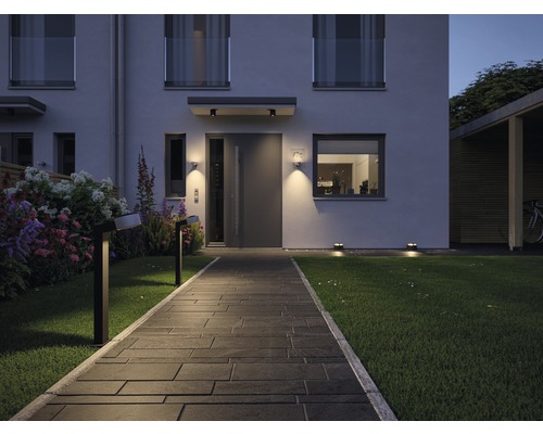 Verlichte tuinpad naar een modern huis met buitenverlichting