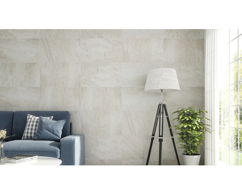 Woonkamer met bank en wandtegels in steenlook.