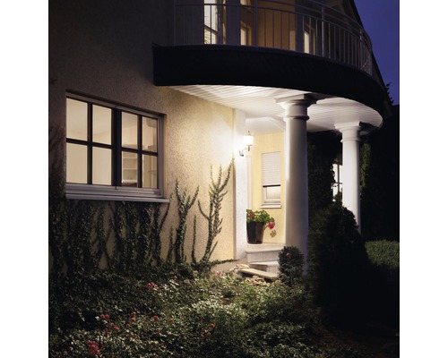 Verlicht woonhuis met tuin in het donker.