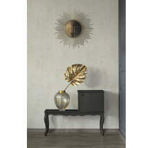 Decoratief interieur met een spiegel in de vorm van een zon, een gouden kunstplant en een commode