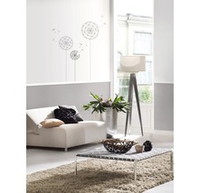 Lichte woonkamer met bank, tafel, lamp en muursticker met paardenbloem