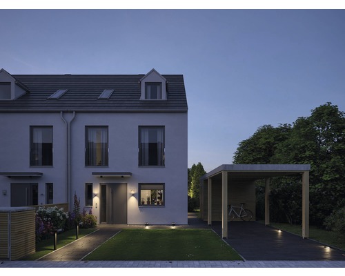 Rijtjeshuis met carport en tuin in de schemering