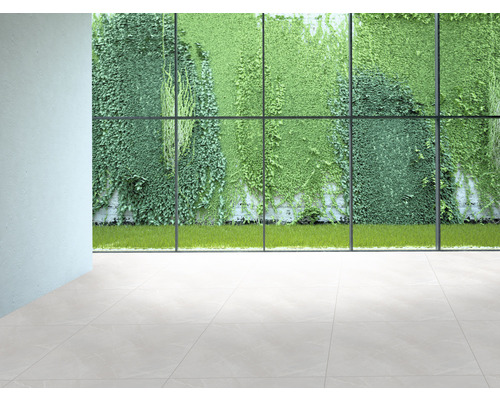 Interieur met tegelvloer en uitzicht door een groot raam op een groene plantenmuur.