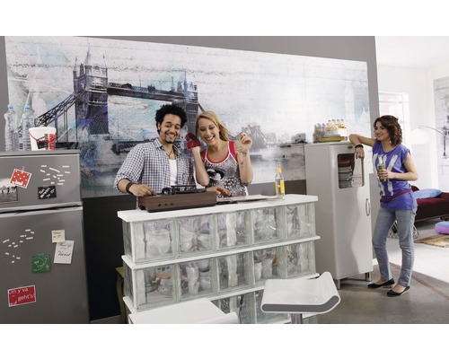 Twee personen draaien platen in een lichte ruimte, terwijl een andere persoon bij een kast staat.