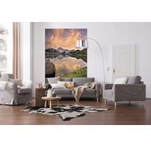 Woonkamer met bank, fauteuil, muurschildering met bergmeer en koeienhuidtapijt