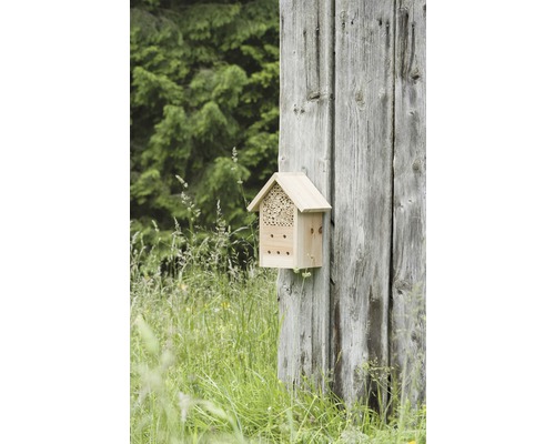 Houten insectenhotel bevestigd aan een houten muur