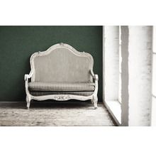 Antieke sofa met houten frame en stoffen bekleding voor een muur