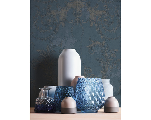 Decoratieve opstelling van diverse vazen tegen een achtergrond van behang met motief.