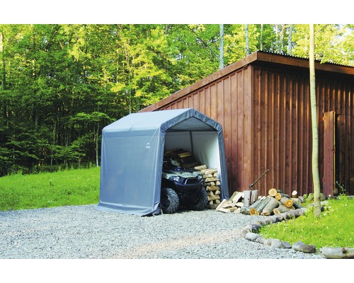 Overkapping met quad en gestapeld hout in de buitenlucht