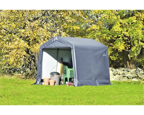 Tuinpaviljoen met tuingereedschap en tuinmeubelen op gazon