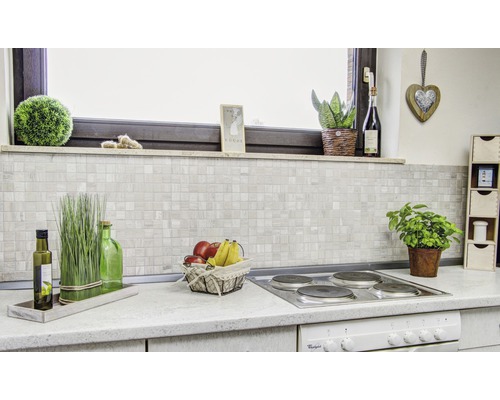 Keukenscène met mozaïektegels achterwand en decoraties op het aanrecht.